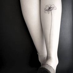 a woman's leg with a flower tattoo on it