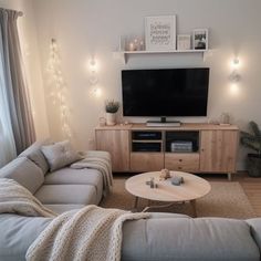 a living room filled with furniture and a flat screen tv mounted on a wall above a wooden coffee table