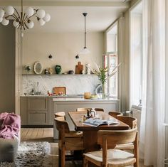 a dining room table and chairs in front of a window