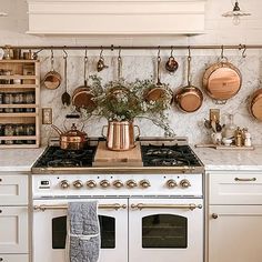 a white stove top oven sitting inside of a kitchen next to pots and pans