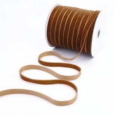 a roll of brown satin ribbon on a white background