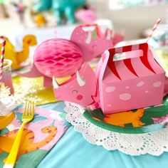 a table topped with plates and cups filled with paper animals on top of each other