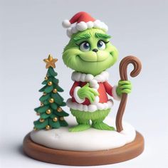 the grinch figurine is holding an umbrella and standing next to a christmas tree