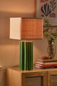 a green lamp sitting on top of a wooden table