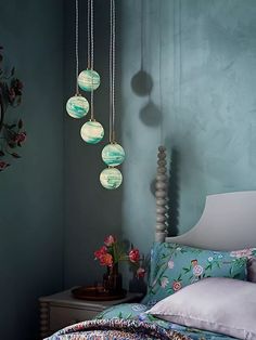 a bed room with a neatly made bed and hanging lights