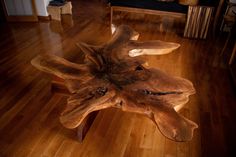 a wooden table made out of logs on a hard wood floor