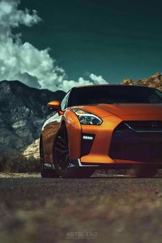 an orange sports car parked in the mountains