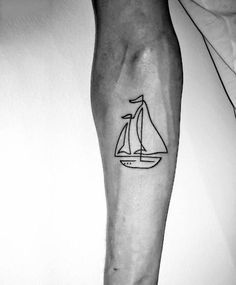 a black and white photo of a man's arm with a sailboat tattoo on it