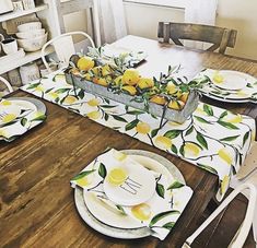 the table is set with lemons and plates