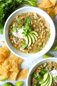 two bowls filled with beans, avocado and tortilla chips