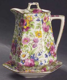 a tea pot and saucer decorated with flowers