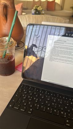 an open laptop computer sitting on top of a table next to a cup of coffee