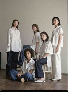 four women in white shirts and jeans sitting on the floor