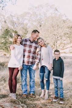 a family poses for a photo in an open field