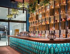 the bar is decorated with green plants and hanging lights