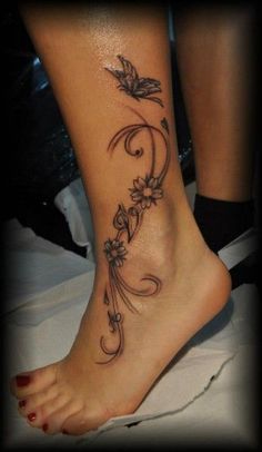 a woman's foot with flowers and vines on the bottom part of her leg