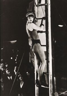 an old black and white photo of a woman in a diving suit on a ladder