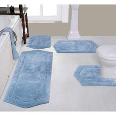 blue bathroom rugs on the floor in front of a white bathtub and toilet