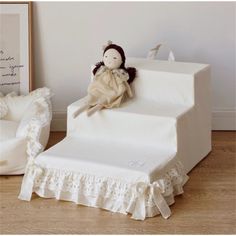 a stuffed doll sitting on top of a set of stairs next to a baby crib