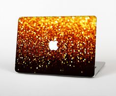 an orange and gold glitter apple laptop skin