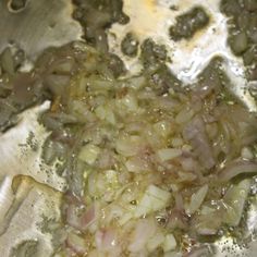 onions are being cooked in a pan on the stove top with oil and seasoning