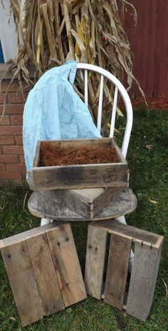 an old chair is sitting in the grass next to some wood blocks and a blue cloth