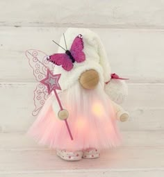 a pink and white teddy bear dressed up as a fairy with a butterfly on its back