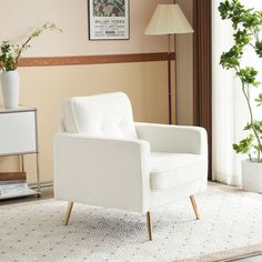 a white chair sitting on top of a rug in a living room next to a window