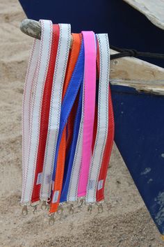 colorful ribbons hanging from a boat on the beach