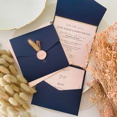 the wedding stationery is laid out on a plate with dried flowers and pamodia