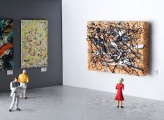 two people looking at paintings in an art gallery