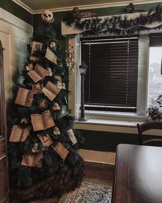 a decorated christmas tree in the corner of a room next to a window with shutters