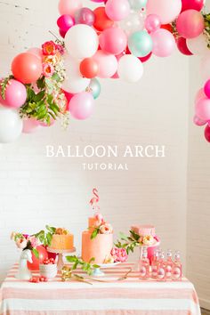 balloons are hanging from the ceiling above a table