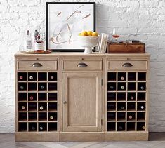 a wooden cabinet with wine bottles in it and a painting on the wall behind it