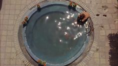 people are sitting at the edge of an empty pool