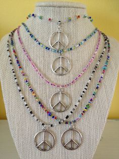 ** PLEASE NOTE - I'm making a bunch in different colors If you want a custom color/length necklace or like one that shows sold, let me know and a custom necklace can be made for you These necklaces are made with glass seed beads. The silver metal peace sign charm is 1-1/8 inch in height and 1 inch in width. The necklace is 19-1/2 inches long. The beads are strung on nylon coated steel wire with a lobster claw closure. It can also be worn as an anklet because the necklace will wrap around the ank Personalized Round Beads Jewelry For Festival, Personalized Festival Jewelry With Round Beads, Peace Sign Jewelry, Collar Hippie, Hippie Crafts, Peace Necklace, Peace Sign Necklace, Beaded Necklace Designs, Sign Necklace