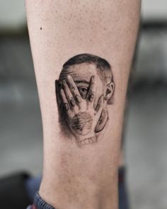 a man's head with hands covering his face on the side of his leg