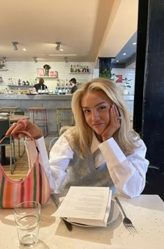 a woman sitting at a table with a purse