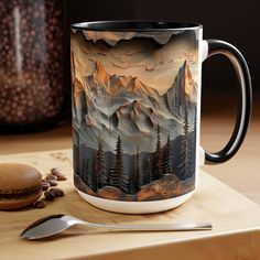 a coffee mug sitting on top of a wooden table next to a spoon and cup