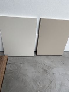 two white tile panels sitting next to each other on the floor in front of a wall