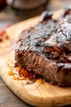 a steak on a cutting board covered in bbq sauce