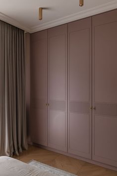 an empty bedroom with large closets and curtains on the windowsill, along with a bed