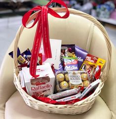 a wicker basket filled with chocolates, candy and candies sits on a chair