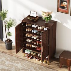 a wooden shoe rack with many pairs of shoes on it next to a potted plant