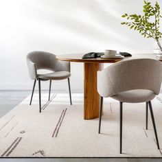 two chairs sitting at a table with a potted plant in the corner on top