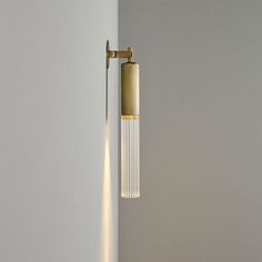 a light that is on the side of a wall next to a white wall with a black floor