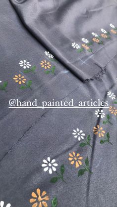 the fabric has flowers on it and is gray with orange, white and green colors