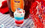 an ice cream sundae with sprinkles on a checkered table cloth