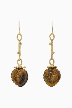 Our Galia Earring is adorned with a tiger’s eye gemstone that’s three-dimensionally carved by hand in India into a striking cockle shell—the nautical influence nods to Ulla’s beach travels, while the heart shape references her love of Victorian pieces. The gleaming brass silhouette is lovingly hand-forged in Kenya as a continuation of our artisan partnerships. This beauty fastens with hook closures. Due to the handcrafted nature of our jewelry, each is uniquely beautiful and one-of-a-kind. All o Luxury Amber Carved Necklace, Adjustable Gold Eye-shaped Jewelry, Luxury Artisan Shell-shaped Jewelry, Elegant Tortoiseshell Drop Earrings, Tiger Eye Earrings Jewelry, Resort Jewelry, Tiger Eye Earrings, Carved Heart, Tigers Eye Gemstone