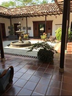 an outdoor patio with a fountain and chairs